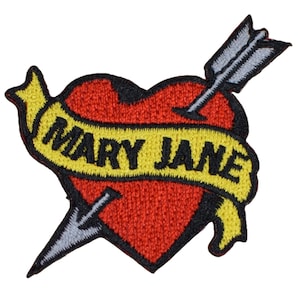 May include: Embroidered patch featuring a red heart pierced by a gray arrow. A yellow banner across the heart reads "MARY JANE" in black letters. The patch has a black border.