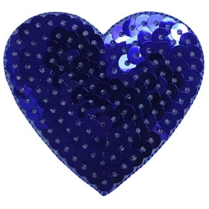 May include: A blue heart-shaped patch covered in sequins. The sequins are small and round, and they are arranged in a close-packed pattern.