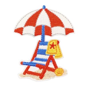 May include: An embroidered patch featuring a red and white striped beach umbrella over a blue and white striped lounge chair. A yellow towel with a red starfish and a yellow seashell rest on the sand at the base of the chair.