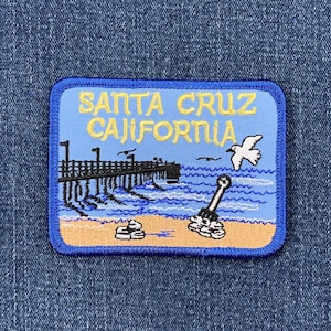 May include: Blue and yellow embroidered patch with the text "SANTA CRUZ CALIFORNIA" and a pier, ocean, and seagull design.