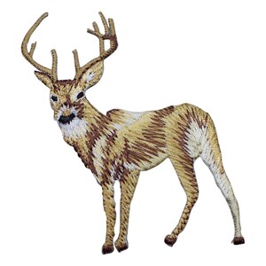 May include: An embroidered patch featuring a standing deer with large antlers. The design uses shades of tan, brown, and white thread to create a textured appearance, showing the animal in profile with its head turned toward the viewer.