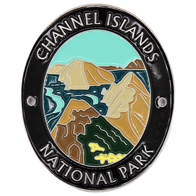 May include: A round, silver-colored metal pin with a black border. The pin features a colorful illustration of a mountainous landscape with a blue sky and the text "CHANNEL ISLANDS NATIONAL PARK".