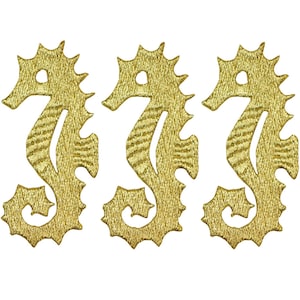 May include: Three gold-coloured seahorse-shaped iron-on patches. The seahorses are detailed with a textured pattern.