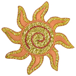 May include: A gold and peach embroidered sun with a spiral design in the center. The sun has 10 points.
