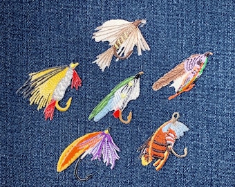 May include: Embroidered fishing lures in various colours, including yellow, red, green, and orange, with detailed stitching. Each lure features a curved hook and is set against a blue denim background.