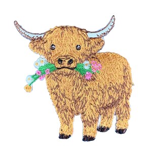 May include: An embroidered patch featuring a shaggy brown Highland cow with long curved horns. The cow is holding a green stem with small white and pink flowers in its mouth. The design has a textured appearance with detailed stitching.