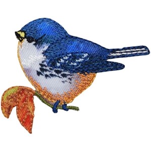 May include: Embroidered patch of a bluebird perched on a branch with a leaf. The bird has blue and white feathers, with orange and yellow accents. The branch and leaf are in shades of green, orange, and yellow.