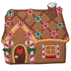 Könnte beinhalten: Ein braunes Lebkuchenhaus mit weißem Zuckerguss und roten und grünen Süßigkeiten-Dekorationen. Das Haus hat eine rote herzförmige Tür und Zuckerstangen-Säulen.
