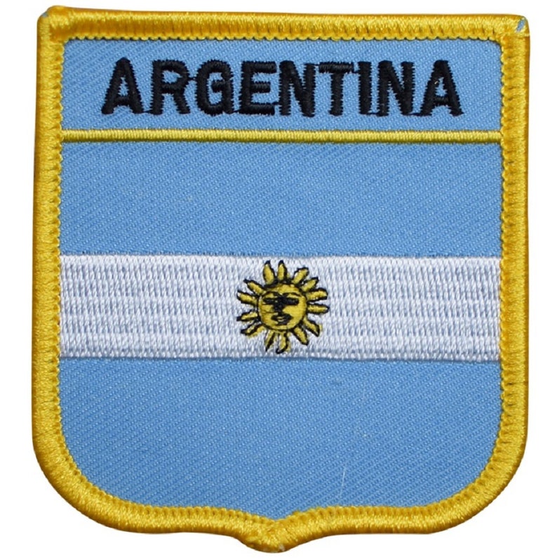 May include: A blue and white embroidered patch with a yellow sun and the word "ARGENTINA" in black lettering. The patch has a yellow border.