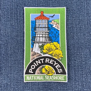 May include: A green and white embroidered patch with a lighthouse, flowers, and the text "Point Reyes National Seashore".