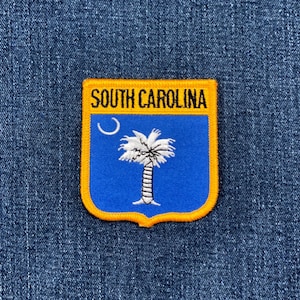 May include: A rectangular patch featuring the South Carolina state flag design. The patch has a blue background with a white palmetto tree and crescent moon. The text "SOUTH CAROLINA" is in gold letters.