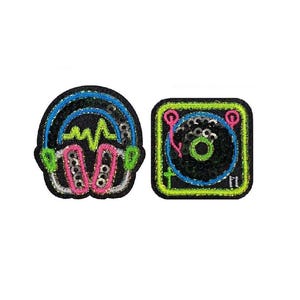 May include: Two embroidered patches: one of headphones with a sound wave, and another of a record player. The headphone patch has blue, pink, green, and silver accents. The record player patch has green, pink, blue, and silver accents. Both patches are on a black background.
