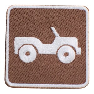May include: A brown fabric patch with a white embroidered image of a jeep. The jeep has a white outline and white wheels.