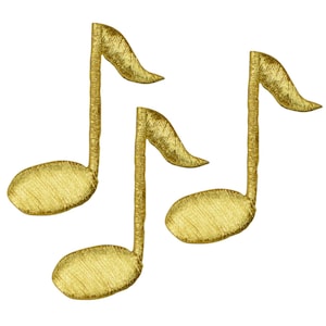 May include: Three gold-coloured musical note patches with a textured, embroidered appearance. The notes are in a treble clef style, with a curved stem and a rounded head. The background is plain white.