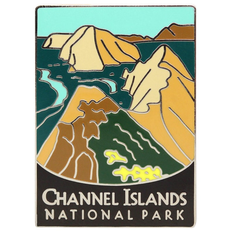 May include: A silver enamel pin with a colorful illustration of a landscape with mountains and water. The text 'CHANNEL ISLANDS NATIONAL PARK' is printed in white on a black background at the bottom of the pin.