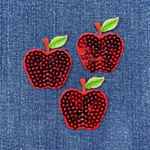May include: Three red sequined apple iron-on patches with green felt stems and leaves.