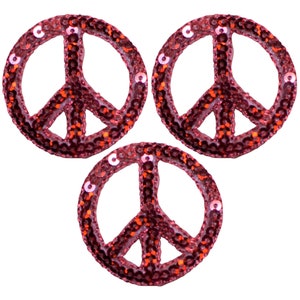 May include: Three pink peace sign patches with sequins. The peace signs are outlined in orange sequins.