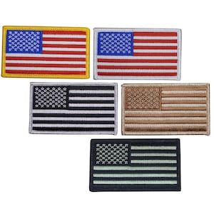 May include: Five rectangular embroidered patches of the American flag. The patches feature the stars and stripes design in various color schemes, including red, white, blue, black, and tan. The patches are likely for clothing or accessories.