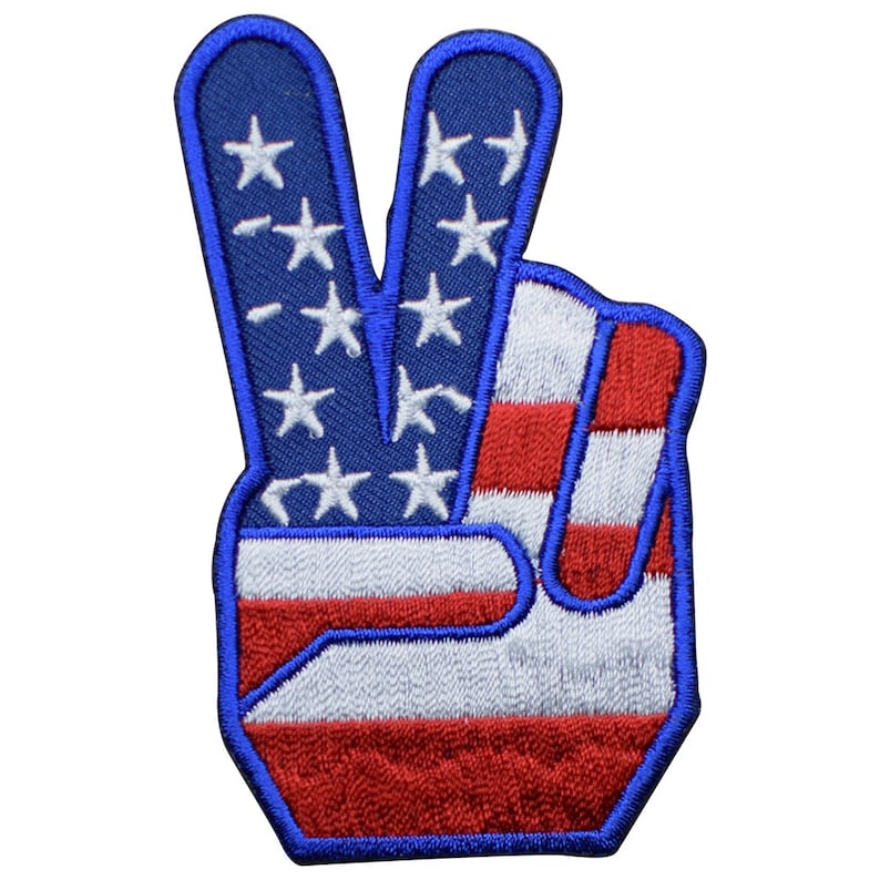 May include: A red, white, and blue peace sign patch with an American flag design. The patch is embroidered with white stars on a blue background and red and white stripes.