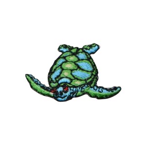 Könnte beinhalten: Gestickter Aufnäher einer Meeresschildkröte in Grün- und Blautönen. Die Schildkröte hat ein detailliertes Design mit einem roten Auge und ist vor einem weißen Hintergrund platziert. Dieser Aufnäher ist für Kleidung oder Accessoires geeignet.