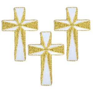 May include: Three embroidered crosses with a gold and white design. The crosses have a detailed, textured appearance, with gold thread outlining the edges and radiating from the center. The background is plain white.