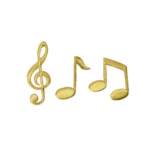 May include: Three gold-colored embroidered patches featuring musical symbols. The set includes a treble clef, a single eighth note, and a pair of beamed eighth notes. Each patch has a textured, metallic thread finish with distinct stitching.