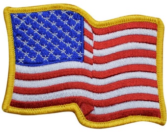 May include: A small, embroidered American flag patch with a yellow border. The flag is waving in the wind.