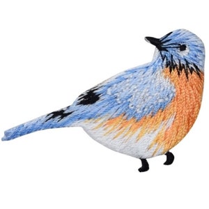 Pu&ograve; includere: Toppa ricamata a forma di uccello con un design blu, arancione e bianco. L'uccello ha becco e zampe neri, con cuciture dettagliate che creano un aspetto strutturato. Adatto per abbigliamento o progetti artigianali.