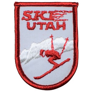 May include: Red and white embroidered patch with the text "SKI UTAH" and a skier in red and white on a white background.