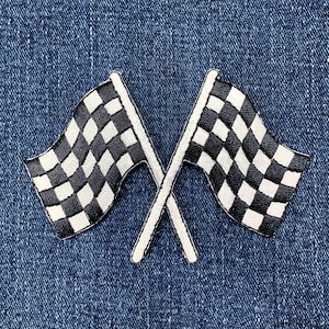 以下が含まれることがあります： 青いデニムの背景に、白い縁取りのある、交差した白黒のチェッカーフラッグが2つあります。 フラッグはスピードと競争の象徴です。