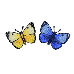 May include: Two embroidered butterfly patches, one in shades of yellow and cream with black outlines, and the other in shades of blue and navy with black outlines. Both patches feature detailed wing patterns and antennae.