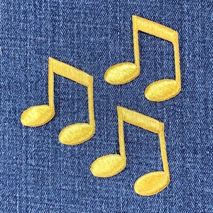 May include: Four gold musical note patches on a blue denim background.