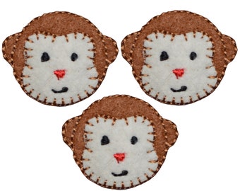 May include: Three brown felt monkey faces with white faces and red noses. The monkey faces are stitched with brown thread around the edges.