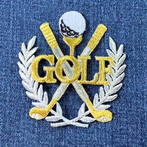 May include: A gold embroidered patch with the word "GOLF" in a white wreath. Two crossed gold golf clubs with a white golf ball on top are behind the word "GOLF".