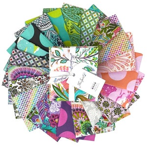 May include: A collection of 20 fabric squares in a variety of colors and patterns, including floral, geometric, and abstract designs. The fabric squares are arranged in a fan shape and are tied together with a white ribbon. The label on the fabric squares reads "Free Spirit".
