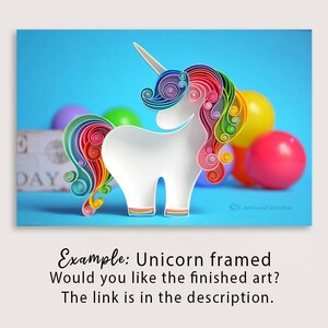 K&ouml;nnte beinhalten: Eine wei&szlig;e Einhornfigur aus Papier-Quilling mit einer bunten Regenbogenm&auml;hne und einem Schweif aus eng gewickelten Papierstreifen. Das Einhorn hat ein einzelnes Horn und steht vor einem hellblauen Hintergrund mit unscharfen Kugeln.