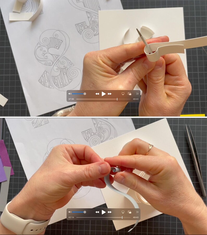K&ouml;nnte beinhalten: Ein Papier-Quilling-Projekt mit wei&szlig;en Papierstreifen, die mit einem Metallwerkzeug geformt werden. Der Prozess umfasst das Rollen und Bearbeiten d&uuml;nner Papierstreifen auf einer wei&szlig;en Oberfl&auml;che mit gedruckten Mustern, was die Kunst des Papierfiligrans zeigt.
