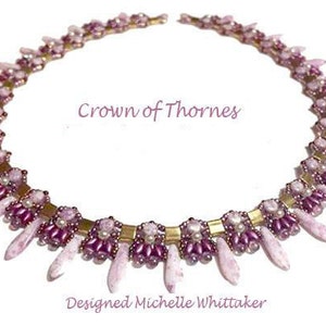 May include: A delicate pink and gold beaded necklace with a crown of thorns design. The necklace is made with small, faceted beads and features a repeating pattern of spikes. The text "Crown of Thorns" and "Designed Michelle Whittaker" is printed below the necklace.