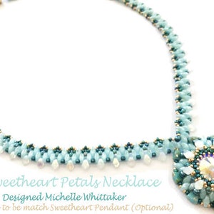 Op de afbeelding: Een lichtblauwe en turquoise kralenketting met een bijpassende hanger. De hanger is rond en heeft een kristal in het midden, omgeven door kleinere kralen. De ketting is bedoeld om te worden gedragen met een bijpassende hanger.