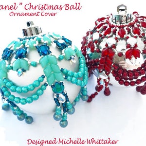 May include: Two silver Christmas baubles with beaded covers. One bauble is decorated with turquoise and blue beads, the other with red beads. The baubles are labelled "Chanel" Christmas Ball Ornament Cover.