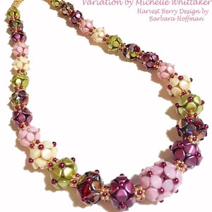 Puede incluir: Un collar de cuentas con una variación del diseño Blooming Harvest Berries de Michelle Whittaker. El collar presenta una variedad de colores, incluyendo rosa, verde, dorado y burdeos.