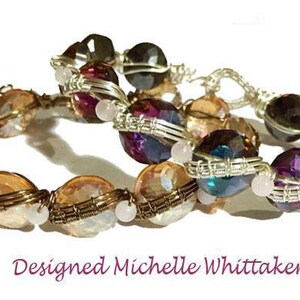 May include: Two wire-wrapped bracelets featuring a variety of coloured glass beads. The top bracelet has dark purple, teal and brown beads. The bottom bracelet has light orange and white beads.
