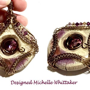 May include: A pendant necklace with a white, round, textured stone set in a gold wire frame. The stone has a smaller, round, purple gem in the center. The pendant is surrounded by smaller purple and clear gems.
