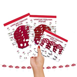 May include: Three packs of red and white mushroom-shaped paper bunting. The packs are labelled "Woodland Toadstool Bunting". The bunting is strung together with twine and features red and white mushroom shapes.