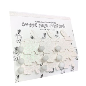 K&ouml;nnte beinhalten: Wei&szlig;er Glitzer-Hasen-Mini-Girlande mit wei&szlig;en Pompons. Die Verpackung lautet "BubbleGum Gift Designs&reg; Bunny Mini Bunting Pack of 12 glitter bunnies".