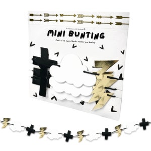 May include: A black and white mini bunting with gold lightning bolts, clouds, and plus signs. The bunting is packaged on a white card with the text "MINI BUNTING" and "Pack of 12 funky Nordic inspired mini bunting".