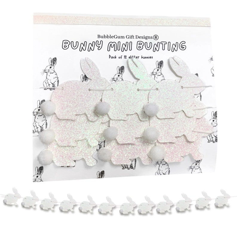 K&ouml;nnte beinhalten: Wei&szlig;er Glitzer-Hasen-Mini-Girlande mit 12 Hasen und wei&szlig;en Pompons. Die Girlande befindet sich auf einem wei&szlig;en Hintergrund mit einem schwarz-wei&szlig;en Hasenmuster. Der Text auf der Karte lautet "BubbleGum Gift Designs&reg; Bunny Mini Bunting Pack of 12 glitter bunnies".