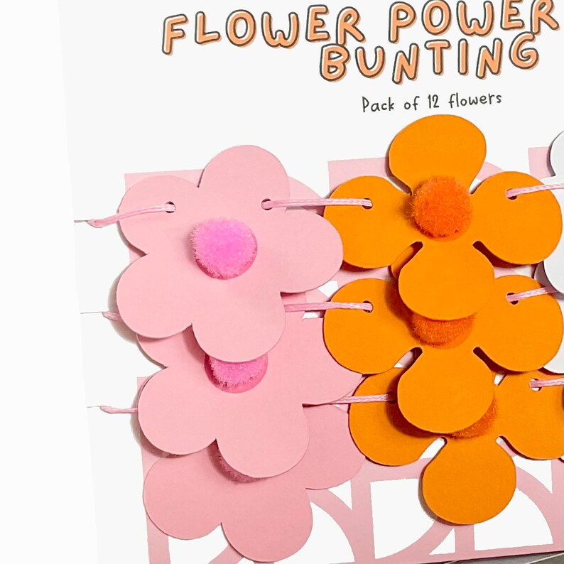 K&ouml;nnte beinhalten: Eine Flower Power Girlande mit 12 rosa und orangefarbenen Papierblumen mit Pompon-Mitten. Die Girlande ist mit wei&szlig;em Garn aufgef&auml;delt. Packung mit 12 Blumen.