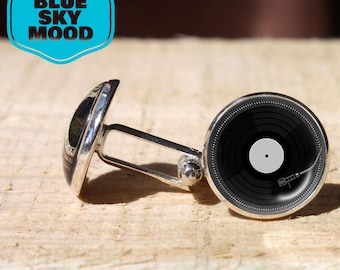 May include: Silver cufflinks with a black vinyl record design. The cufflinks have a round face with a detailed record graphic and a silver backing. The image also includes a blue and white logo that says "BLUE SKY MOOD".