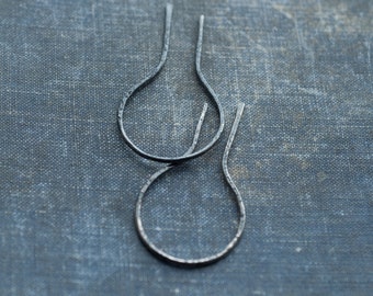 May include: Two silver hoop earrings with a hammered texture.